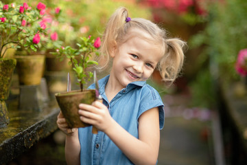 Toddler with flower basket. girl holding pink flowers