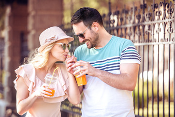 Happy couple in love drinking fresh juice