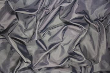 Pleats on rumpled dark gray fabric.