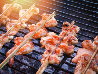 Thai style food grilled chicken wing with bamboo stick on the grill