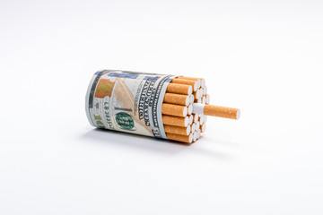 Cigarettes wrapped in hundred dollars banknotes on white background. Waste money.