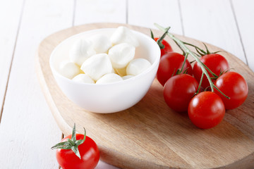 Fresh cherry tomatoes and mozzarella on white background