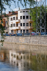 Fototapeta na wymiar Buildings mirrored in the Somes River in Cluj-Napoca.