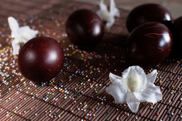 Red painted eggs and white flowers of orchid on table cloth