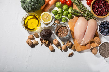Raw fresh chicken breasts and spices on a white background