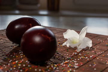 Red painted eggs and white flowers of orchid on table cloth