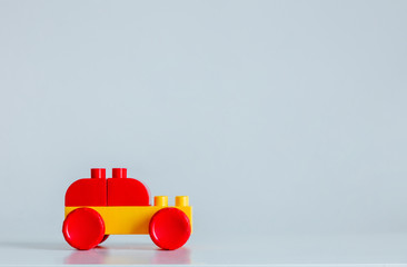 Plastic bricks car in yellow and red color on a table