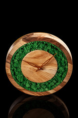 Wooden clock with color stabilized moss on a black background with mirror otgruzheniya. Trend 2019. Wall Clock. copy space