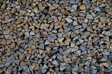 Background of dry chopped firewood logs in a pile
