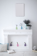 fireplace with decorative ornaments and blank picture on the wall in the living room