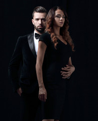 embraced elegant couple holding hands and look at the camera