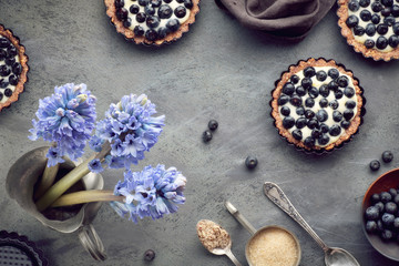 Top view on wholegrain blueberry tarts with vanilla cream on dark