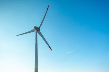 Blades of a wind farm against a blue sky