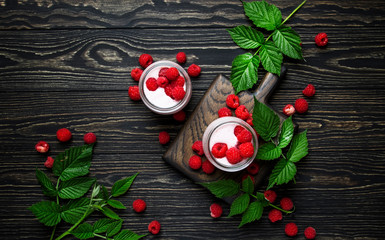 Raspberry smoothie in glass jars with fresh berry and yogurt on vintage wooden kitchen table background, flat lay, top view