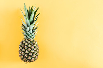 Summer minimal composition. Pineapple on pastel yellow background. Creative summer concept. Flat lay, top view, copy space
