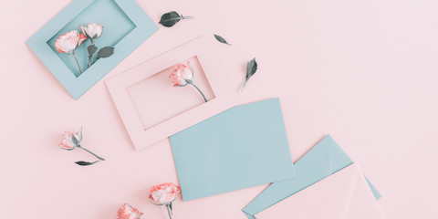 Flowers composition romantic. Pink rose and envelopes on pale pink background. Flat lay, top view, copy space