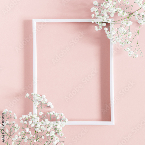 Flowers composition romantic. White gypsophila flowers, photo frame on pastel pink background. Valentine's Day, Easter, Birthday, Happy Women's Day, Mother's day. Flat lay, top view, copy space