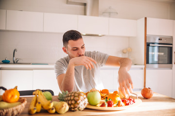 Young caucasian man preparing his healthy smoothie in the morning.