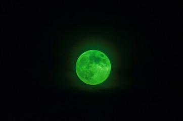 Photo of full moon with black night sky, moon is green