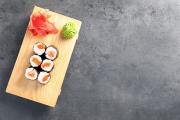 Fototapeta na wymiar Tasty sushi rolls served on grey table, top view with space for text. Food delivery