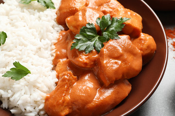 Plate of delicious butter chicken with rice on table, closeup