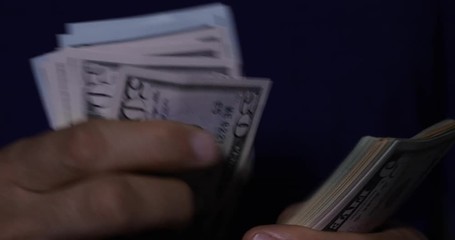 Hands counting $1000 USD with different denominations of bills