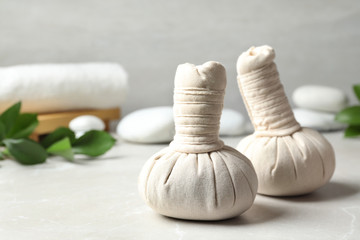 Fototapeta na wymiar Herbal bags for spa massage on table