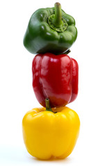 Green, red and yellow bell pepper stacked isolated on white background