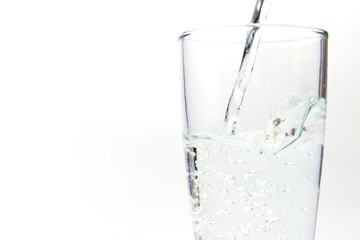 pouring water on a glass on white background 