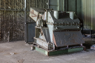 Abandoned machinery forgotten in a factory with rust and faded paint