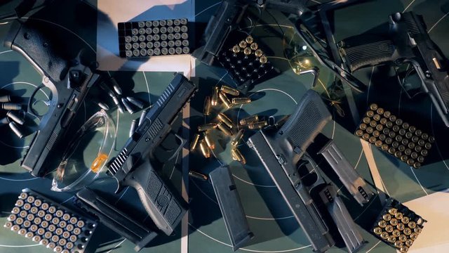 Guns with bullets on a table at a shooting room. 4K