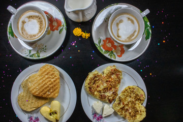 Breakfast on Valentine's Day - fried omelete, bread, apple and White cheese in the shape of a heart  coffe and milk. Top view 