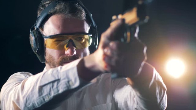 Armed man training at a shooting range, close up.