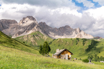 Fototapeta na wymiar Val di Fassa in Estate, paesaggio alpino con baita in estate sulle dolomiti italiane