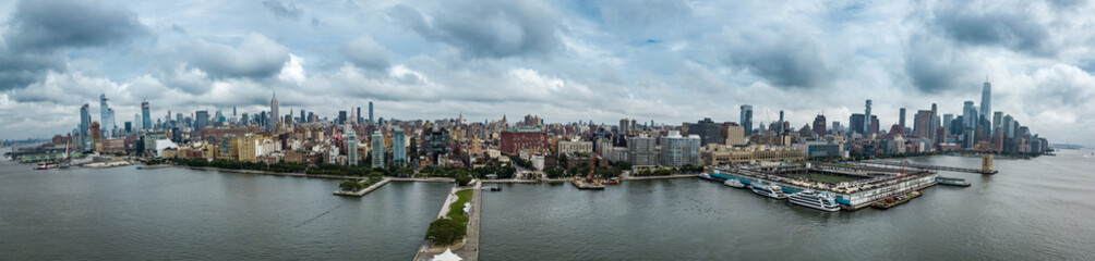 Fototapeta na wymiar Aerial view of Manhattan Midtown and Downtown skyline from above Hudson River on a cloudy day