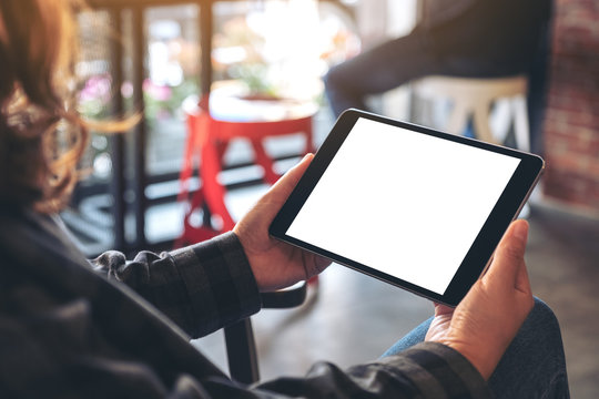 Mockup image of a woman holding black tablet pc with blank screen horizontally in cafe