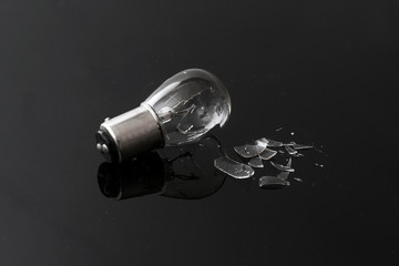 Broken Lamp with Shattered Pieces on Dark Reflective Background, Failure Concept