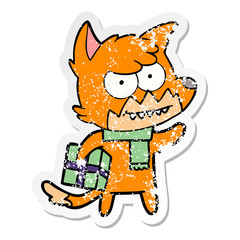 Obraz premium distressed sticker of a cartoon grinning fox with christmas present