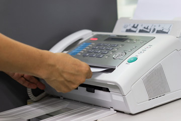 hand  of man are using a fax machine in the office Business concept  - obrazy, fototapety, plakaty