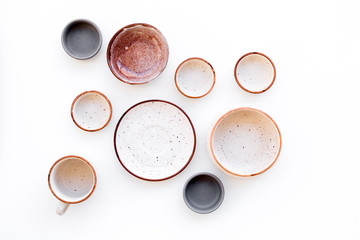 Kitchen concept. Crockery kit. Empty ceramic plates and mugs on white background top view