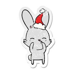 curious bunny distressed sticker cartoon of a wearing santa hat