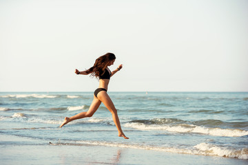 Fototapeta premium Happy slim lady run at sea beach