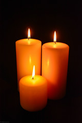 Fototapeta na wymiar three candles on black background