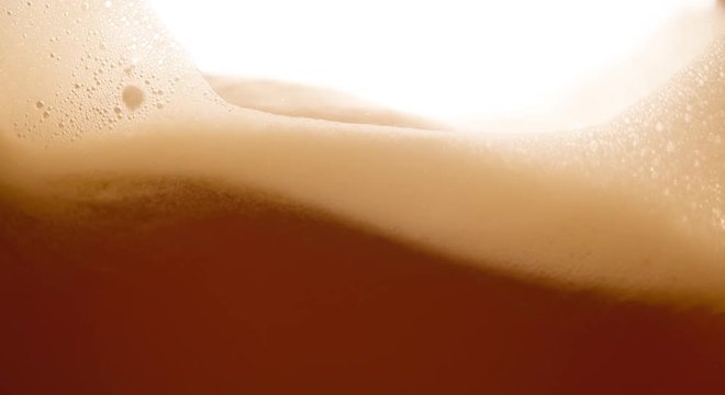 Beer wave background with foam bubbles Extremely closeup slow motion video