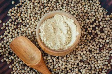 White ground pepper in wooden bowl.