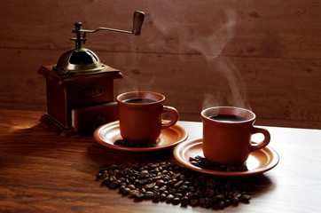 Two cups of hot coffee, from which comes steam.