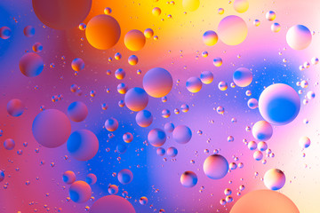 oily drops  in water with colorful background, close-up 