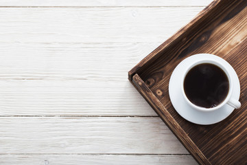 cup of coffee on tray on wooden table