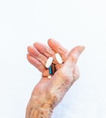 Old hand holding pills