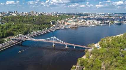 Obraz premium Aerial top view of Kiev city from above, Kyiv skyline, hills, pedestrian Park bridge and Dnieper river cityscape in spring, Ukraine